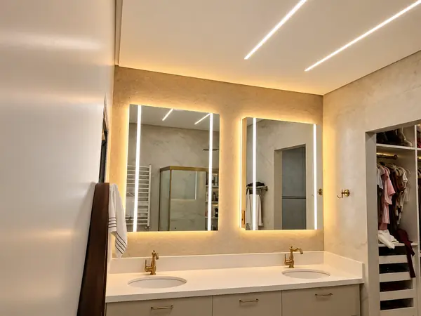 Banheiro com perfis de LED no teto e espelhos