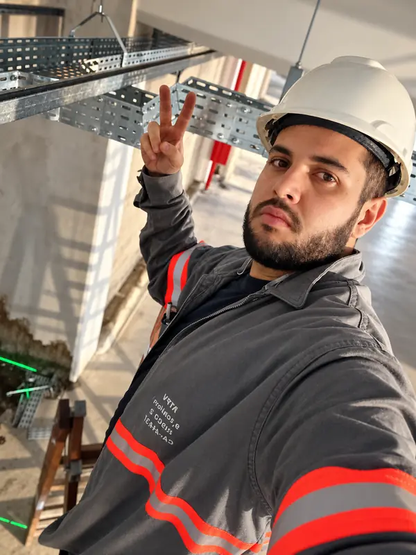 Rhaduan de capacete em obra predial, ao lado de eletrocalhas